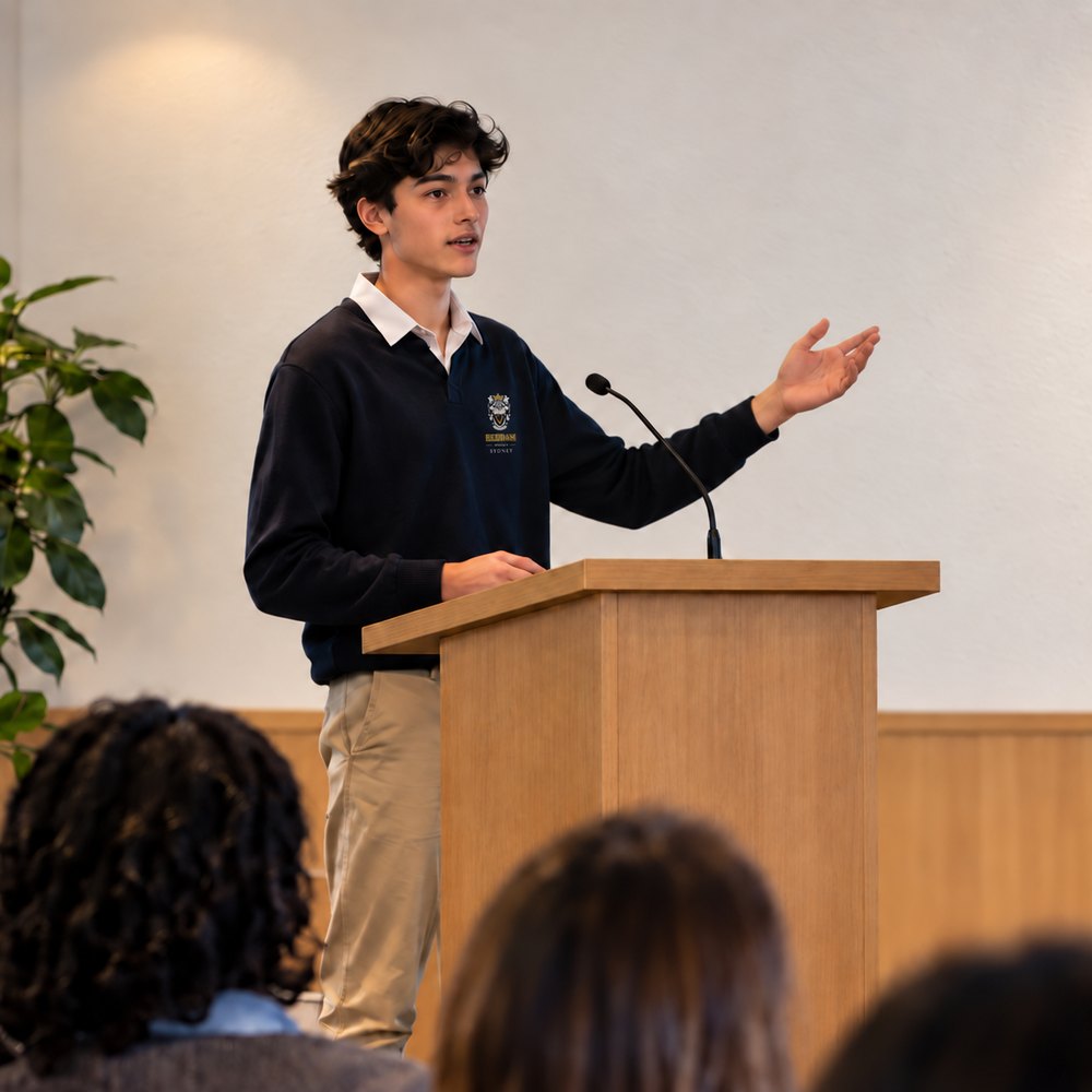 A student presenting his project from a lectern to an audience
