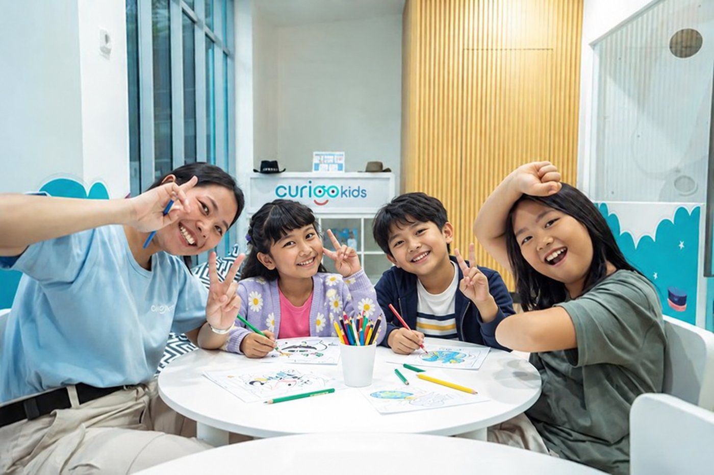 An educator and three children working together at a CURIOOkids table